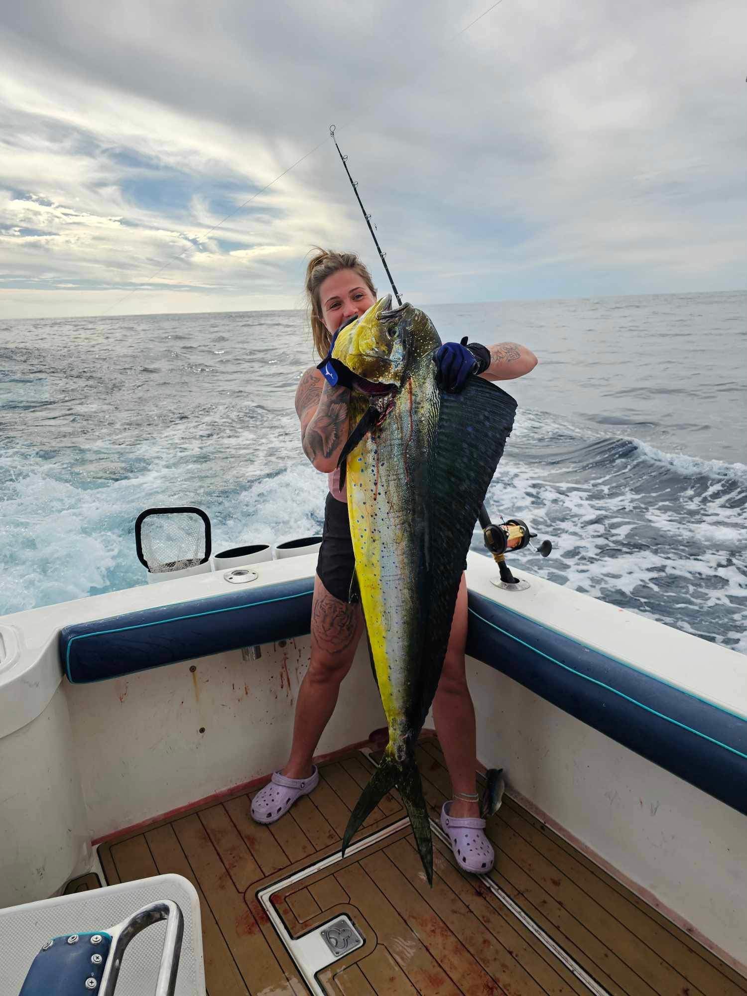 Angler holding large mahi-mahi on boat