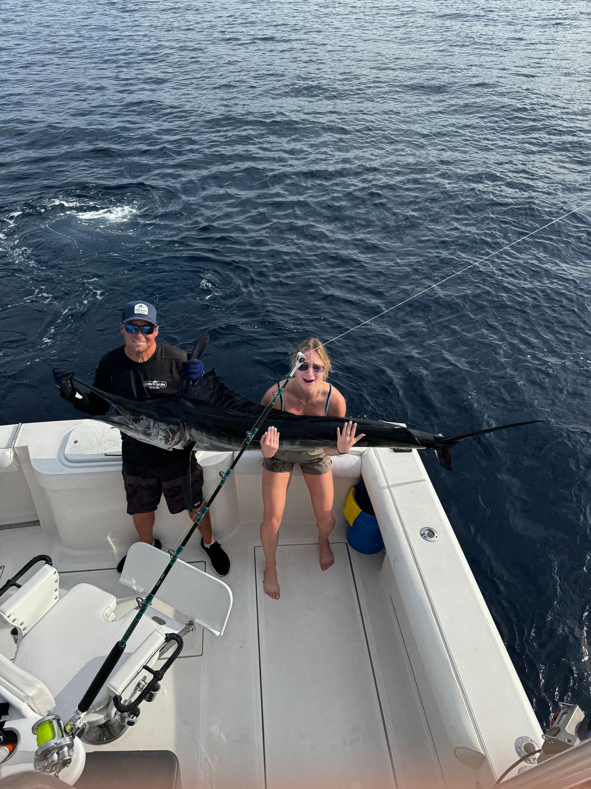 Woman holding large tuna at marina